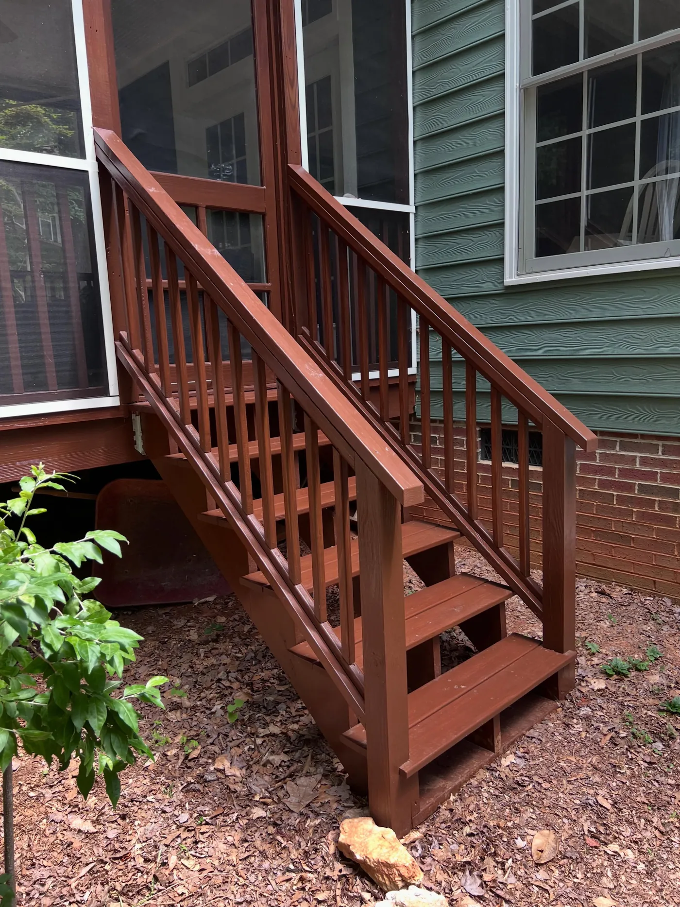 After: rebuilt back stairs, freshly stained, with a continuous top rail