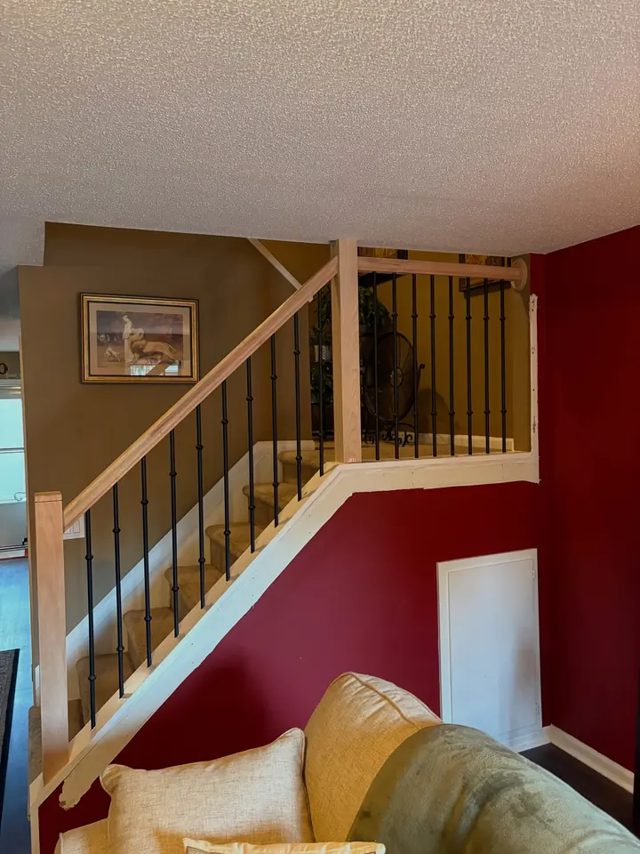 Red oak stair rail with black iron balusters